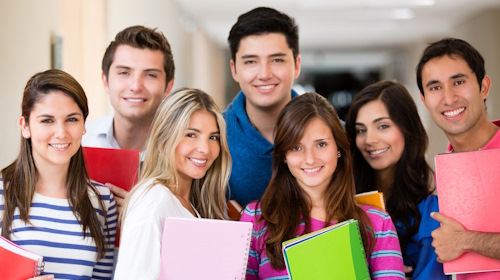 Happy group of college students smiling and holding notebooks